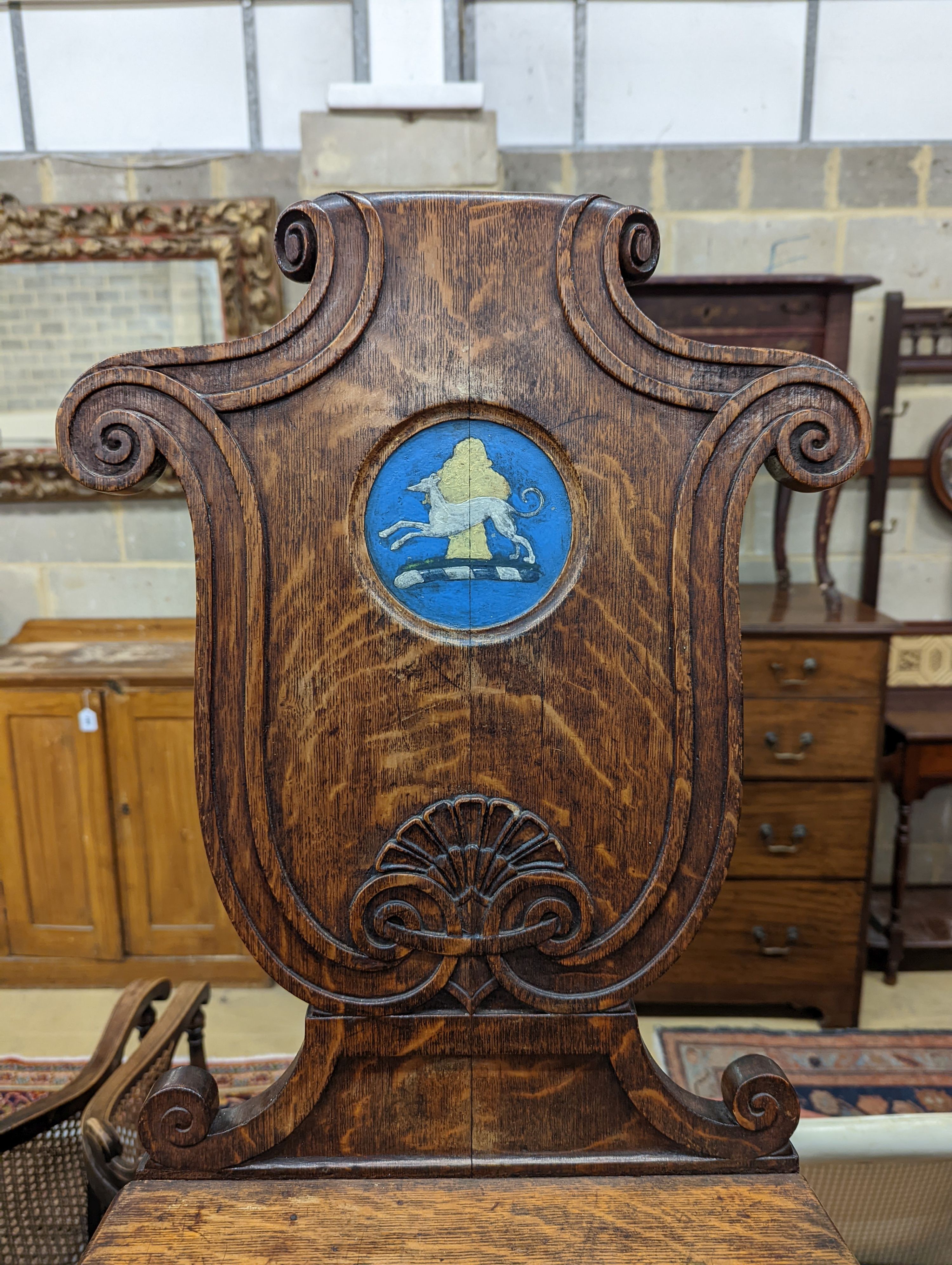 A pair of Victorian oak hall chairs with painted armorials, width 43cm, depth 39cm, height 94cm